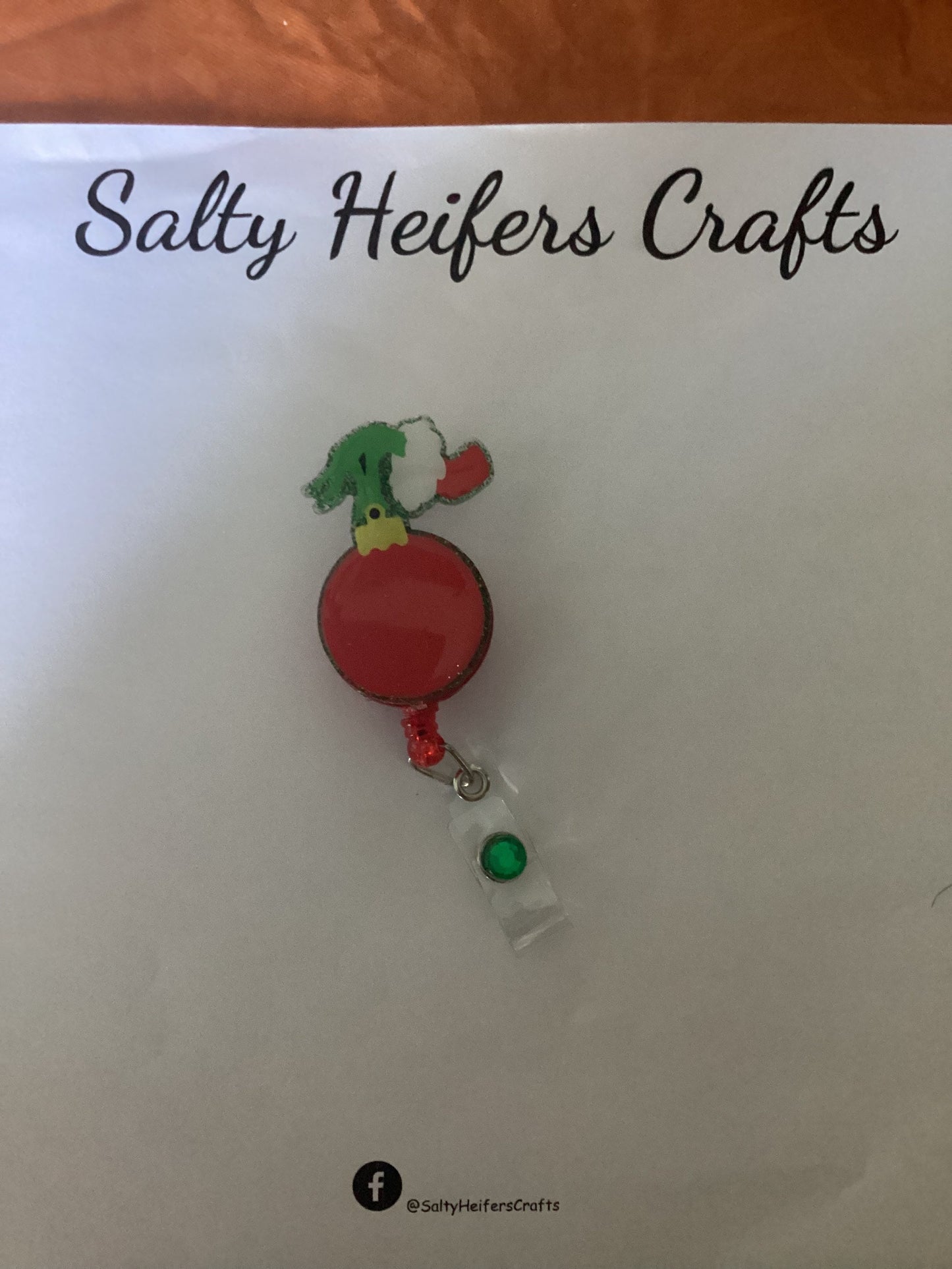 Hand Holding Ornament Badge Reel