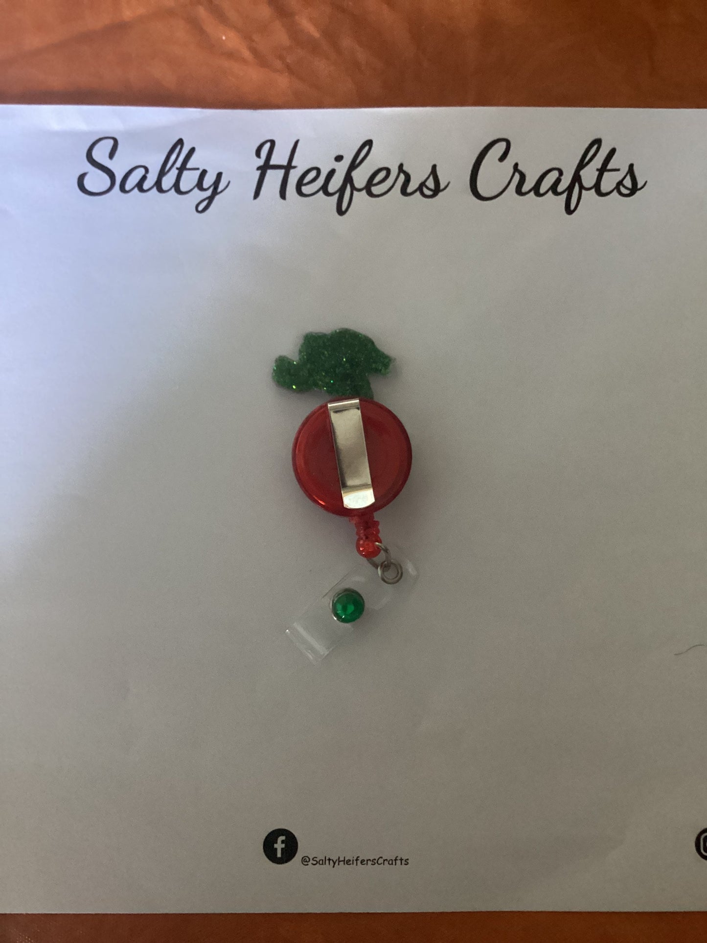 Hand Holding Ornament Badge Reel